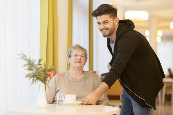 Zivildiener reicht Frau Kaffee (Bild: FSW)